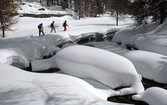 Des marcheurs en raquettes dans la nature de la station de sport d'hiver de Sainte Foy, dans les Alpes