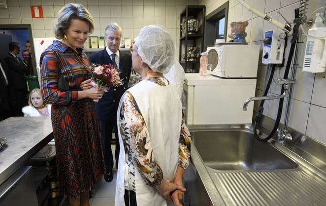 Le roi et la reine Philippe et Mathilde de Belgique visitent la cuisine d'un centre d'alimentaition