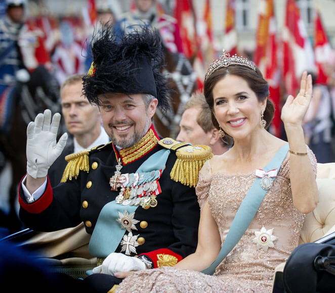 Le couple héritier, le prince Frederik et la princesse Mary de Danemark défilent devant la foule dans une calèche en tenue officielle