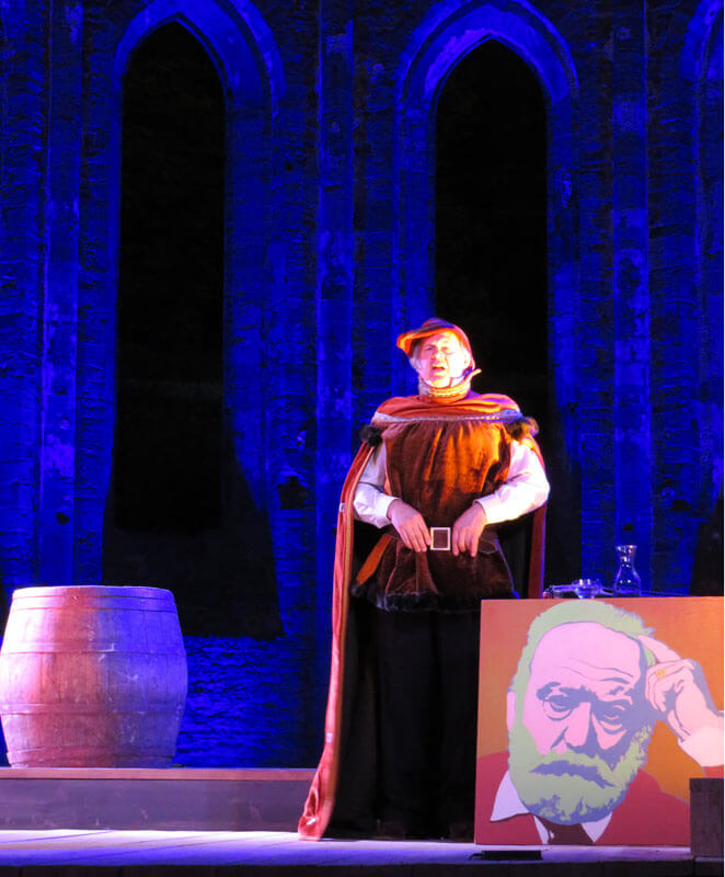 Le comédie Pierre Gringoire dans une adaptation théâtrale de Notre Dame à Villers-la-Ville devant un portrait de Victor Hugo