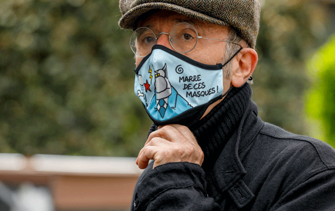 Philippe Geluck portant un masque du Chat