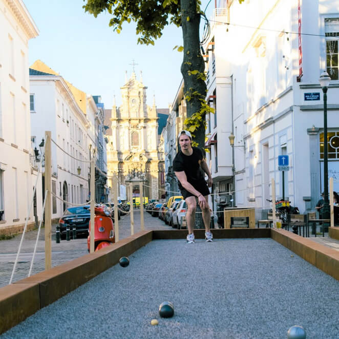 Un jeune jouant à la pétanque