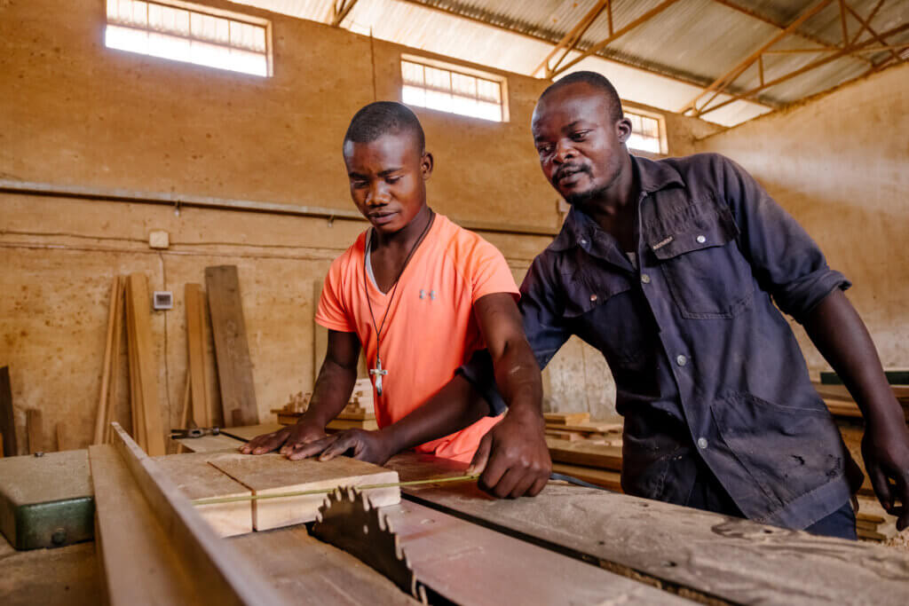 Gloire en apprentissage du métier dans le workshop au centre Don Bosco avec Espoir, formateur menuisier à Don Bosco Bukavu. © Isabel Corthier