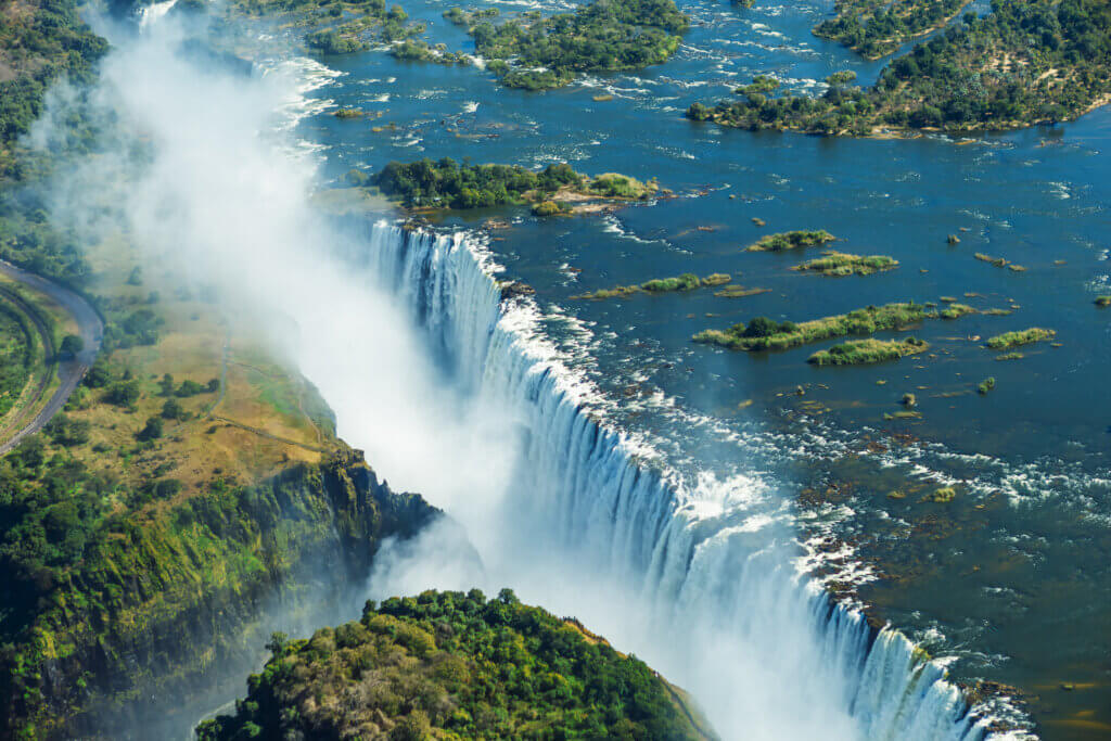 Les chutes Victoria sont le plus grand rideau d'eau du monde (1708 m de large). Les chutes et les environs sont les parcs nationaux et le site du patrimoine mondial (vue en hélicoptère). © DR